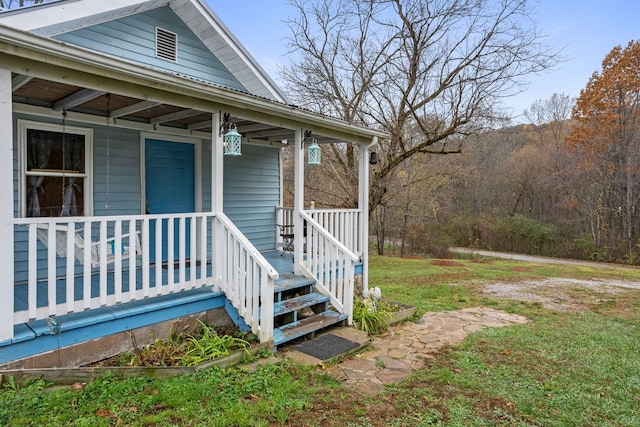 doorway to property with a lawn and covered porch