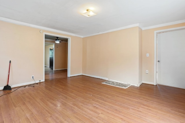 spare room featuring light wood-type flooring and crown molding