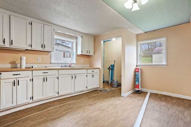 kitchen featuring white cabinets, a healthy amount of sunlight, and light wood-type flooring