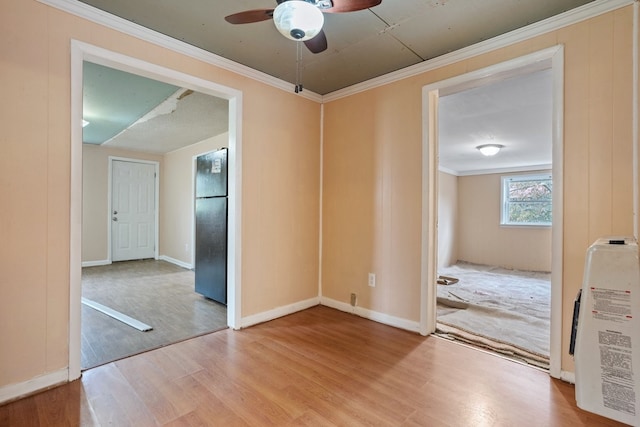 empty room featuring ceiling fan, crown molding, and light hardwood / wood-style flooring