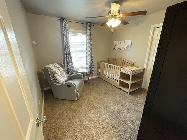 bedroom with carpet flooring, ceiling fan, and a nursery area