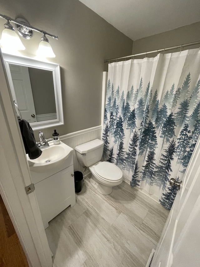 bathroom with a shower with shower curtain, vanity, and toilet