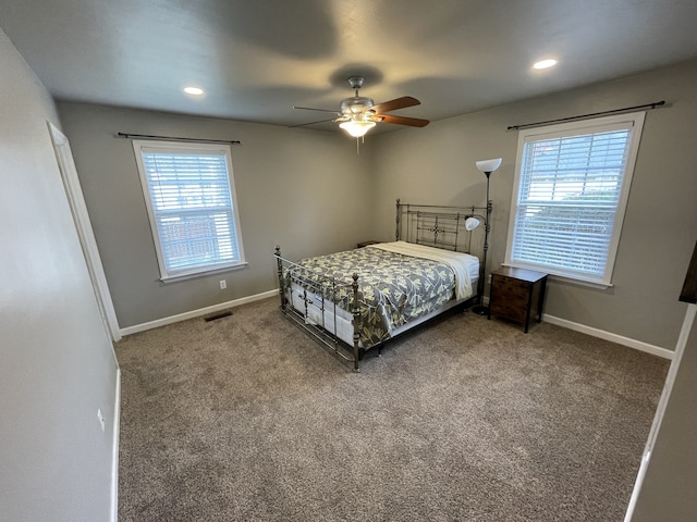 carpeted bedroom with ceiling fan and multiple windows