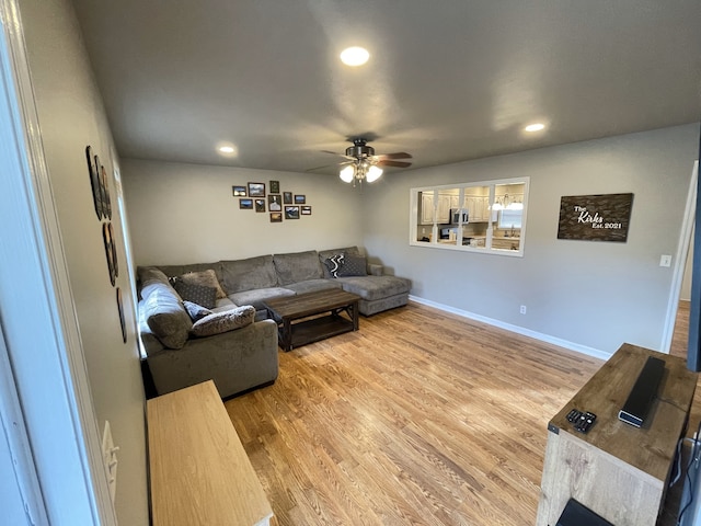 living room with ceiling fan and light wood-type flooring