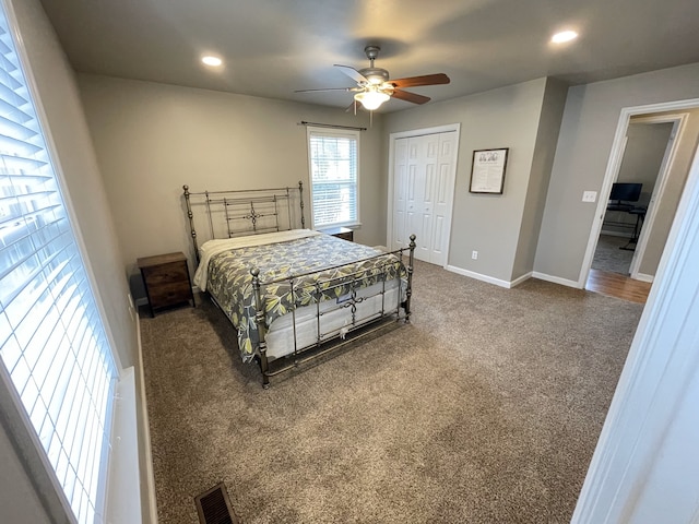 carpeted bedroom with ceiling fan and a closet