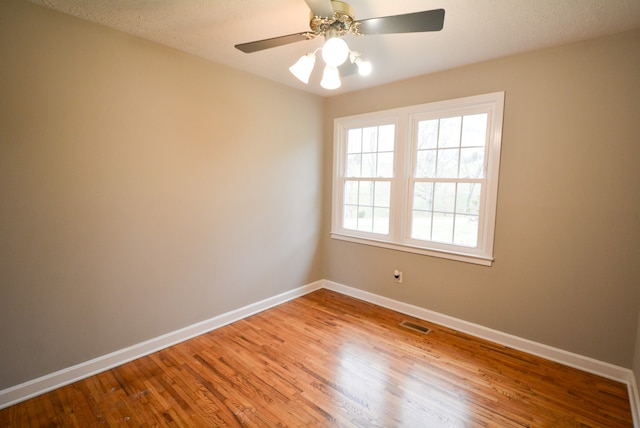 unfurnished room featuring ceiling fan, wood-type flooring, and a textured ceiling