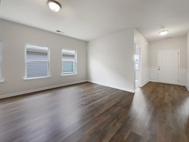 unfurnished room with dark hardwood / wood-style flooring