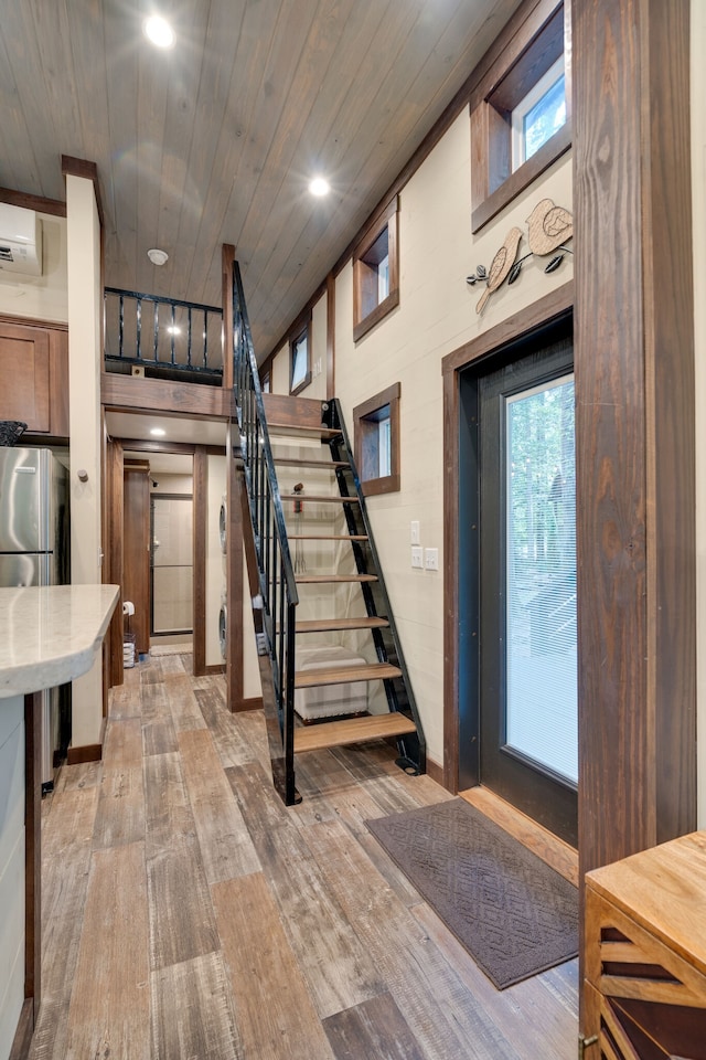 stairway featuring hardwood / wood-style flooring, a wall mounted air conditioner, and wooden ceiling