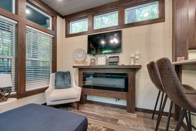 sitting room with wooden ceiling, a healthy amount of sunlight, and wood-type flooring