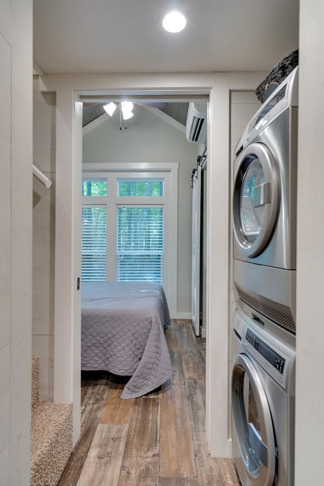 laundry area with hardwood / wood-style floors, ceiling fan, and stacked washer / dryer