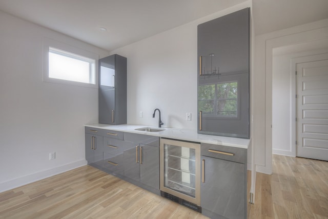 kitchen featuring light wood-type flooring, sink, and beverage cooler