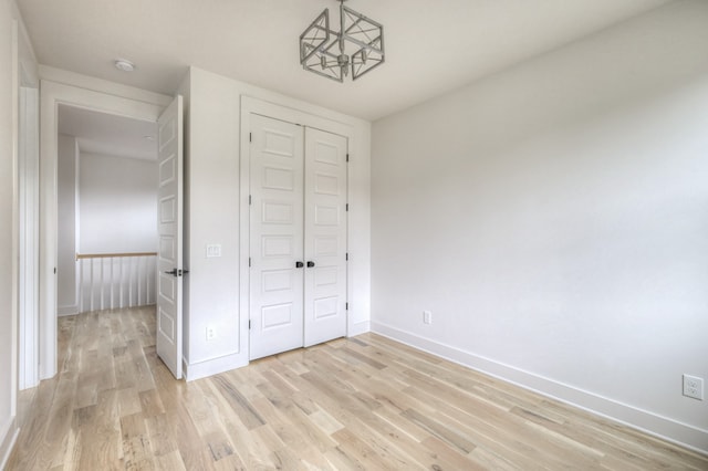 unfurnished bedroom with light wood-type flooring and a closet