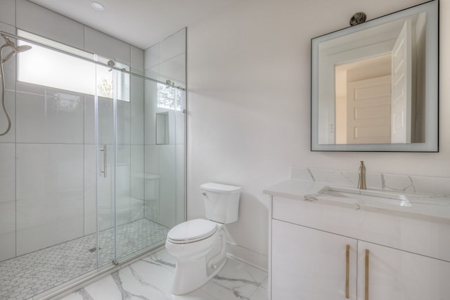 bathroom with vanity, toilet, and a shower with door