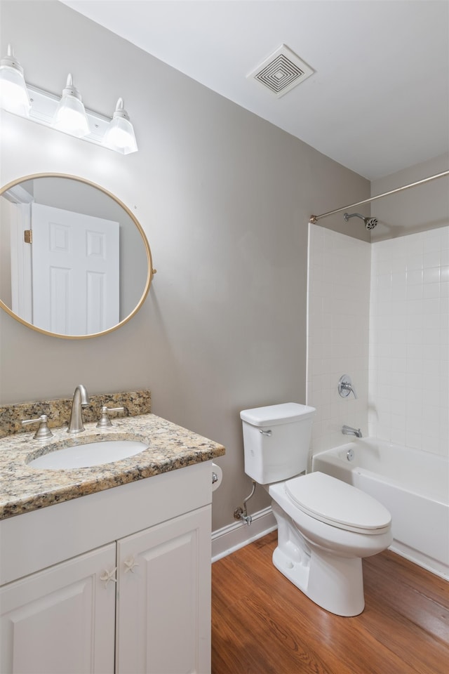 full bathroom with vanity, toilet, wood-type flooring, and tiled shower / bath