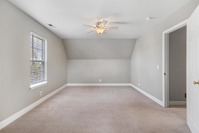 additional living space featuring light carpet, ceiling fan, and lofted ceiling