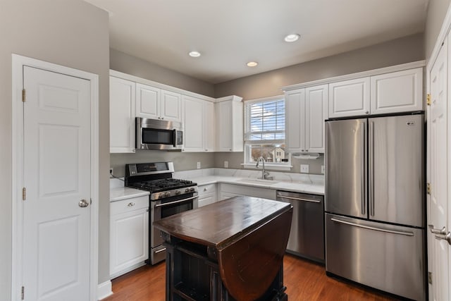 kitchen featuring hardwood / wood-style floors, sink, white cabinets, and stainless steel appliances