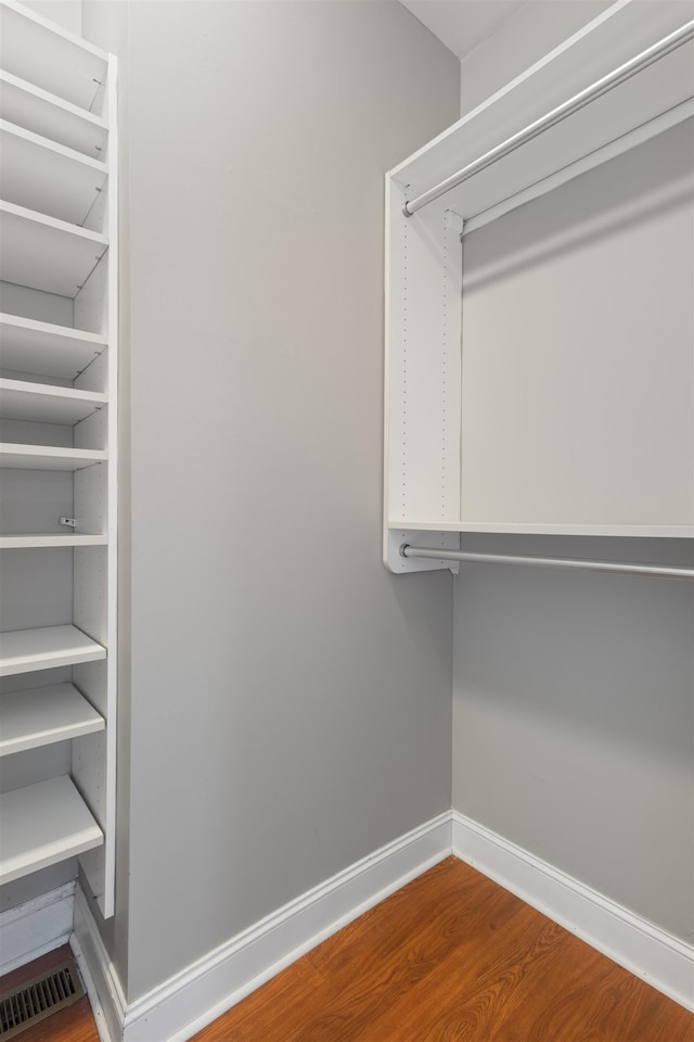 walk in closet with wood-type flooring