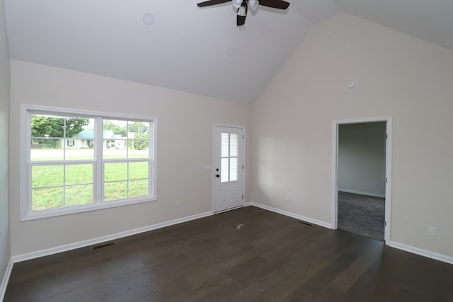 unfurnished room with a wealth of natural light, high vaulted ceiling, dark hardwood / wood-style floors, and ceiling fan