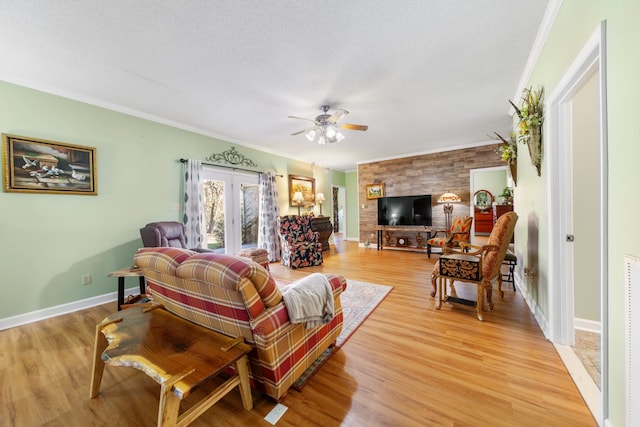 living room with wood-type flooring, a textured ceiling, ceiling fan, and crown molding