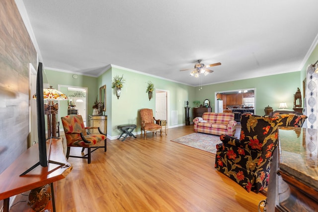 living room featuring ceiling fan, crown molding, and light hardwood / wood-style flooring