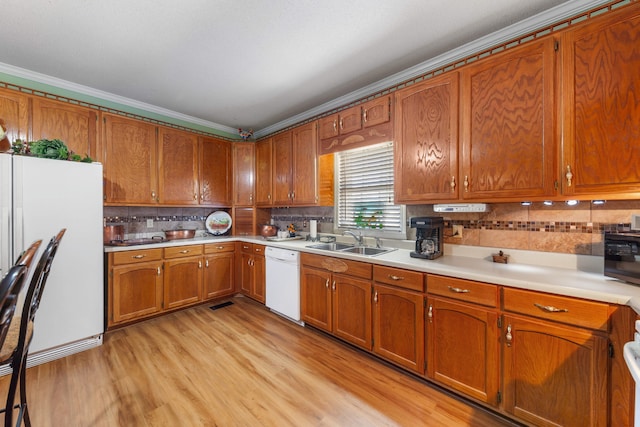 kitchen featuring tasteful backsplash, ornamental molding, white appliances, sink, and light hardwood / wood-style flooring