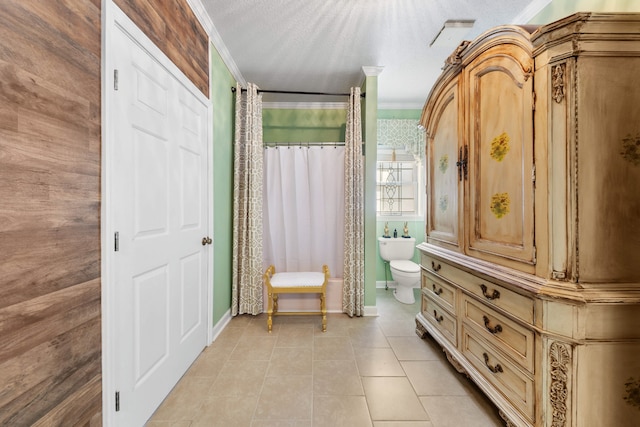 bathroom featuring tile patterned flooring, a textured ceiling, toilet, and crown molding