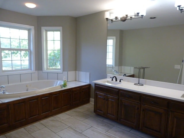 bathroom featuring vanity, a bathtub, and an inviting chandelier