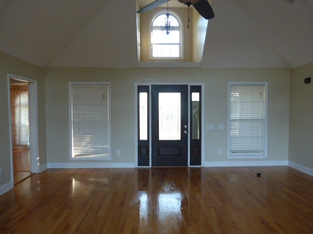 foyer entrance featuring hardwood / wood-style flooring, ceiling fan, and high vaulted ceiling