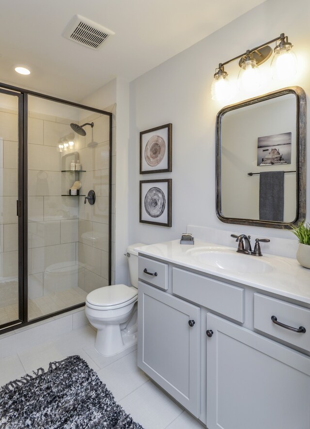 bathroom with toilet, vanity, tile patterned flooring, and a shower with door