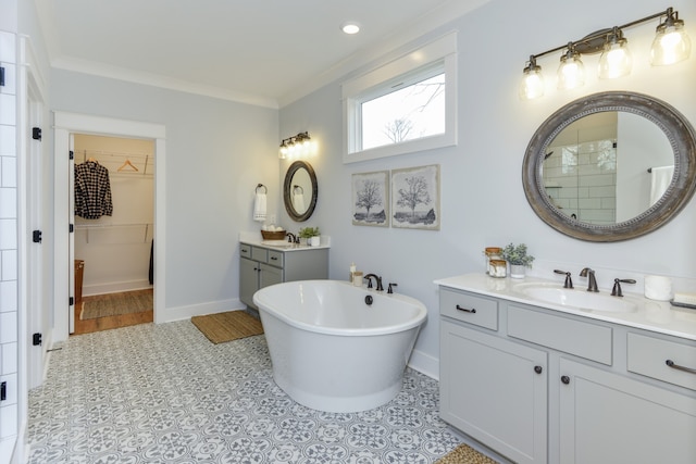 bathroom featuring a bath, ornamental molding, and vanity