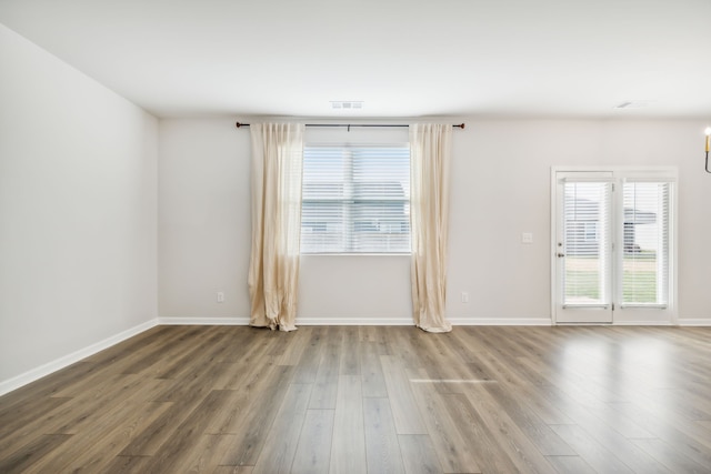 unfurnished room featuring hardwood / wood-style flooring and a notable chandelier