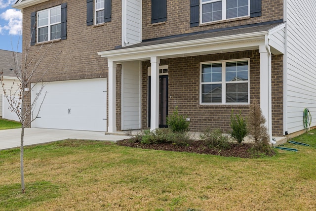 view of exterior entry featuring covered porch, a garage, and a lawn