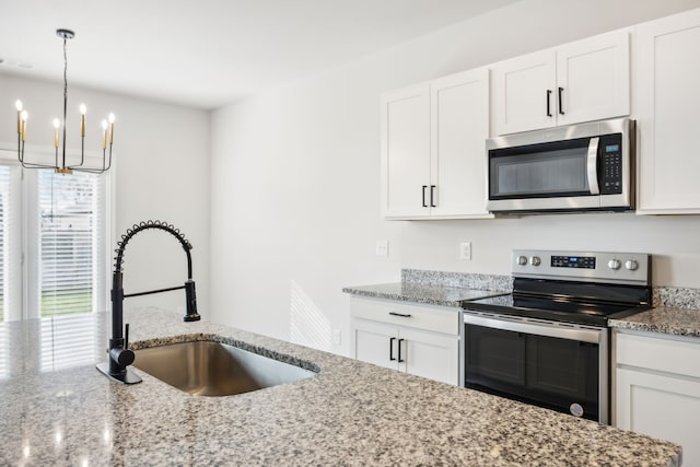 kitchen with appliances with stainless steel finishes, white cabinetry, plenty of natural light, and sink