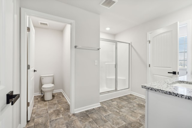 bathroom featuring vanity, toilet, and a shower with door