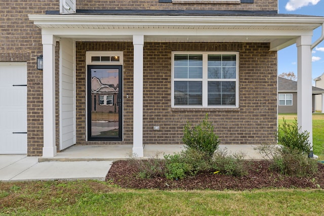 property entrance with covered porch and a garage