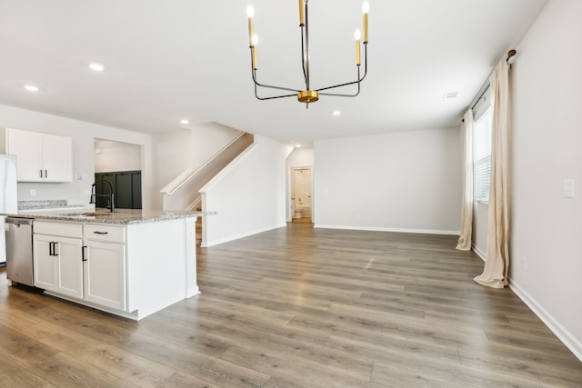 kitchen featuring stainless steel appliances, sink, wood-type flooring, a center island with sink, and white cabinetry