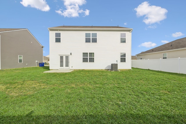 rear view of property with a yard, cooling unit, and a patio