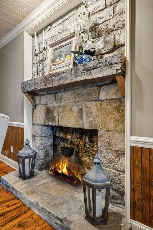 details featuring crown molding, a fireplace, hardwood / wood-style floors, and wooden walls