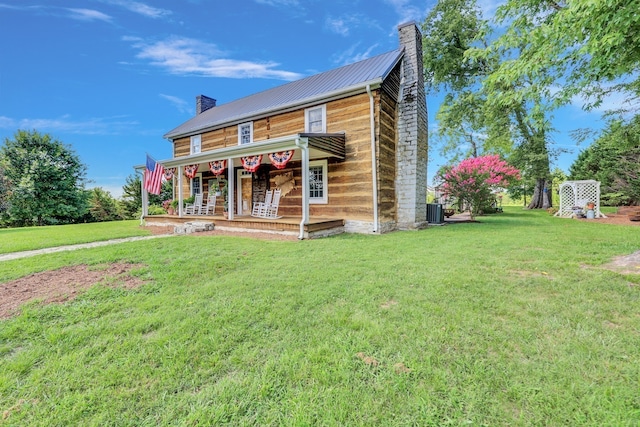 view of front of house with cooling unit, a front lawn, and covered porch