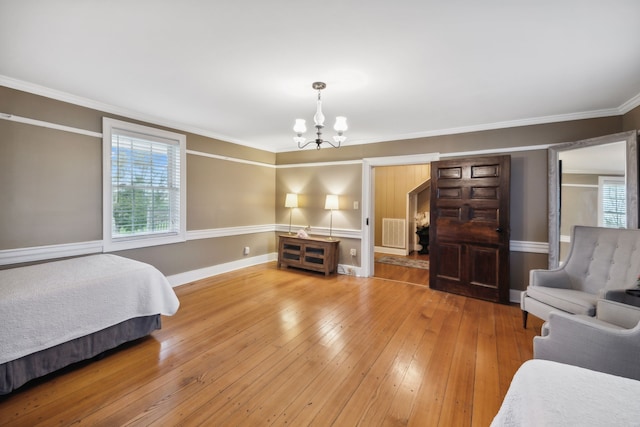 bedroom with hardwood / wood-style flooring, crown molding, and a chandelier