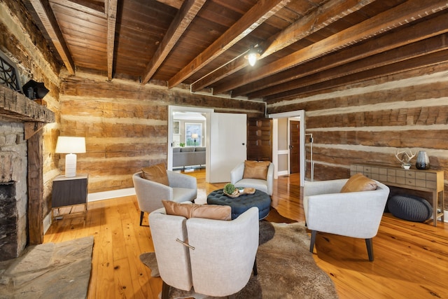 sitting room with beamed ceiling, light hardwood / wood-style flooring, wood walls, and wood ceiling