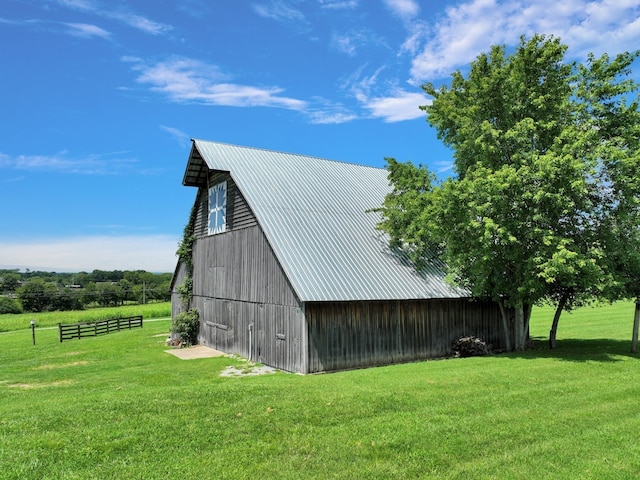 view of outdoor structure featuring a lawn and a rural view