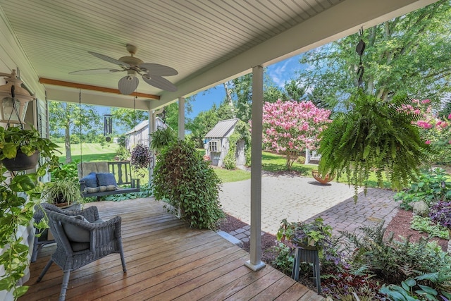 wooden deck featuring ceiling fan and an outbuilding