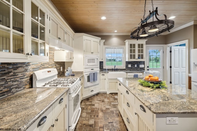 kitchen featuring white appliances, a kitchen island, hanging light fixtures, and sink