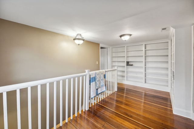 corridor with built in shelves and dark hardwood / wood-style flooring