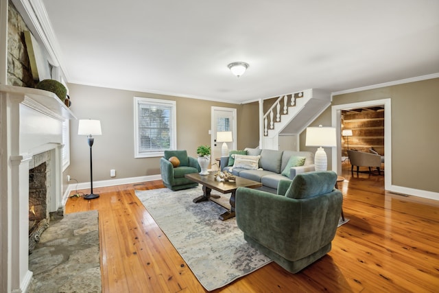 living room featuring a fireplace, hardwood / wood-style flooring, and ornamental molding