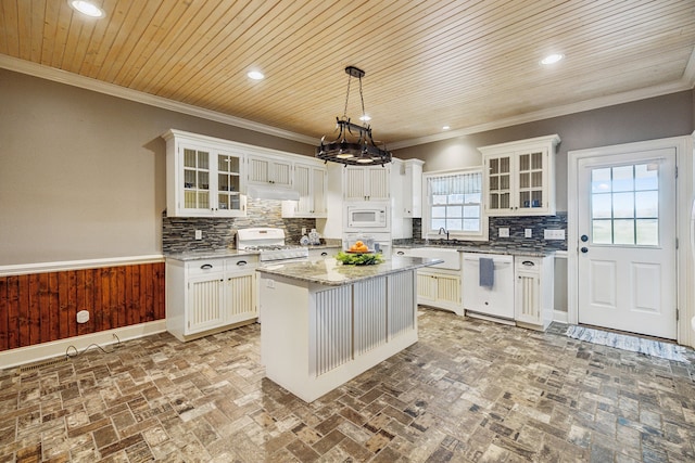 kitchen featuring tasteful backsplash, white appliances, pendant lighting, white cabinets, and a kitchen island