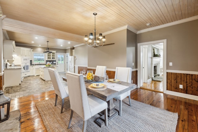 dining area with a notable chandelier, wooden ceiling, crown molding, and light hardwood / wood-style flooring