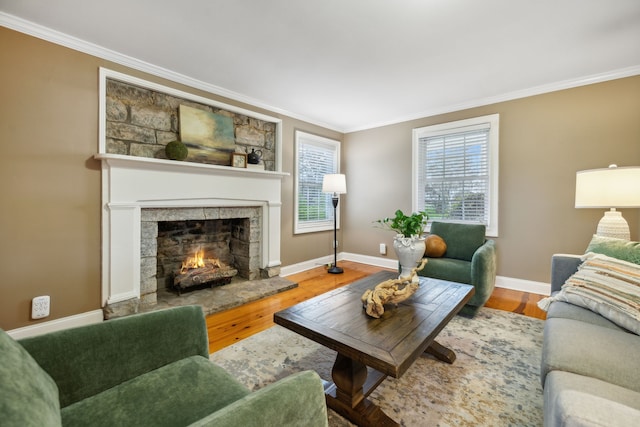 living room with a stone fireplace, crown molding, and hardwood / wood-style flooring