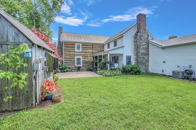 rear view of house with a yard, central AC, and a patio area